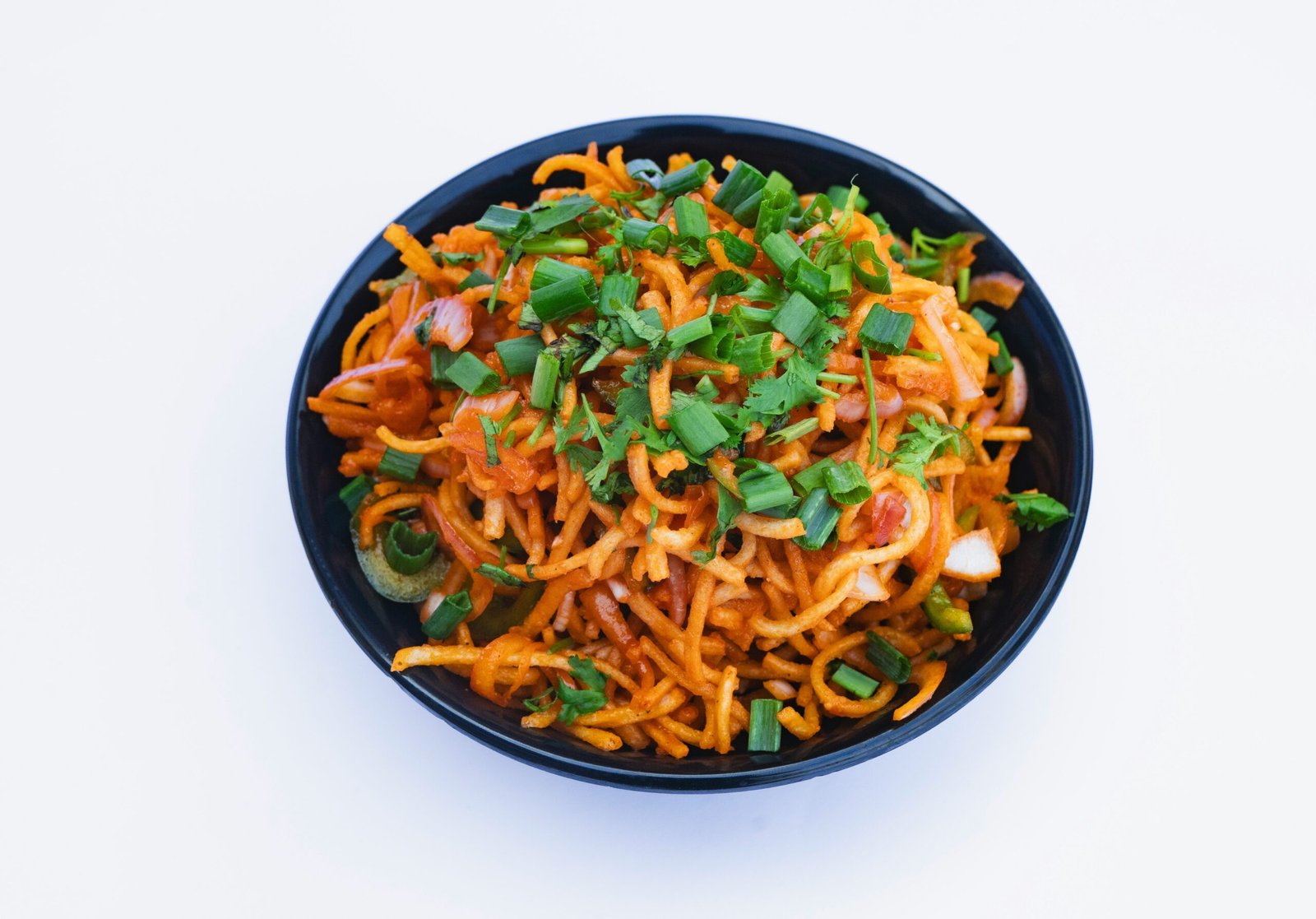 a black bowl filled with noodles and vegetables